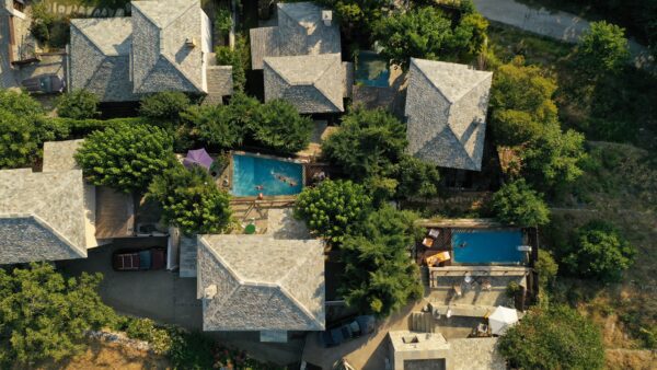 A bird 's eye view of some houses with pools.