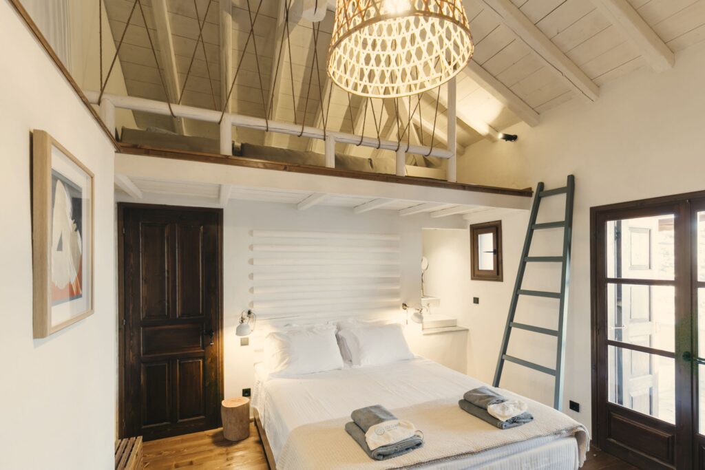 A bedroom with a ladder to the top of the bed.